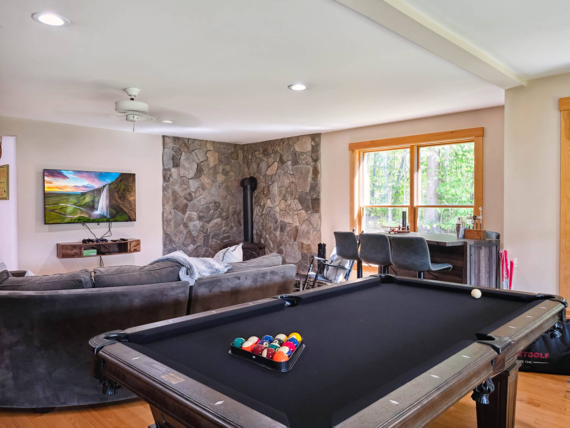 Game room with pool table, seating area, and TV.